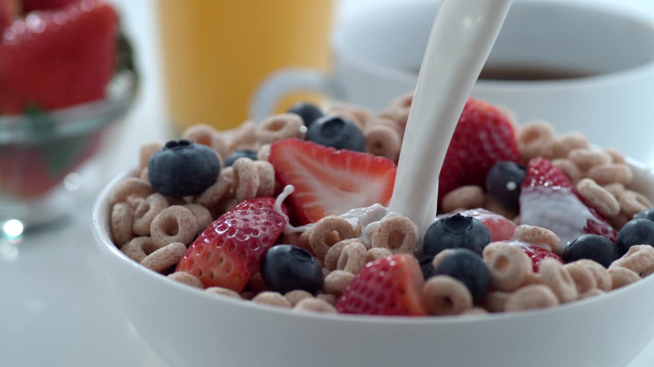la leche se vierte en un cuenco de cereales y bayas