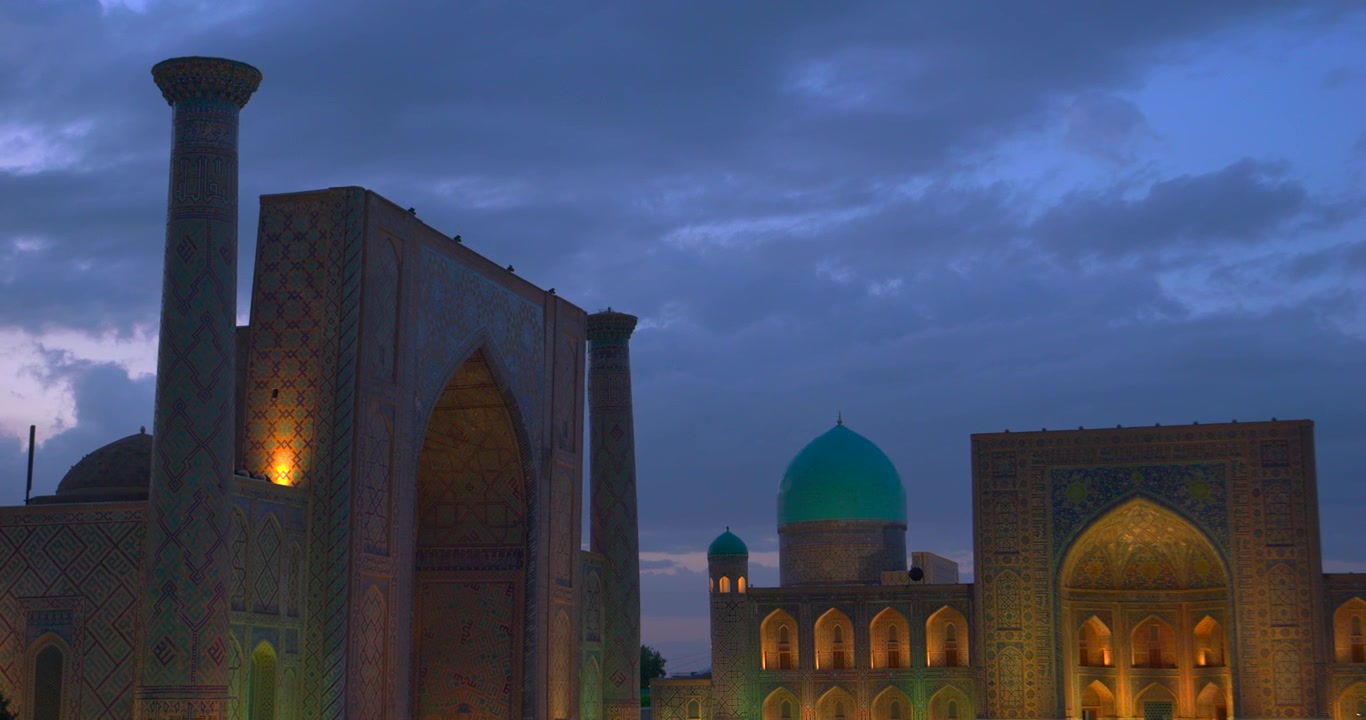 Historic Registan Square at dusk with illuminated madrasahs turquoise dome and ornate tiled minarets in Samarkand Uzbekistan Central Asian architecture travel heritage and evening city landmark concep