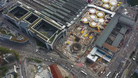 Aerial-of-huge-railroads-and-construction-site-of-main-train-station-Stuttgart-21-with-cranes-and-construction-workers-in-Stuttgart,-Germany