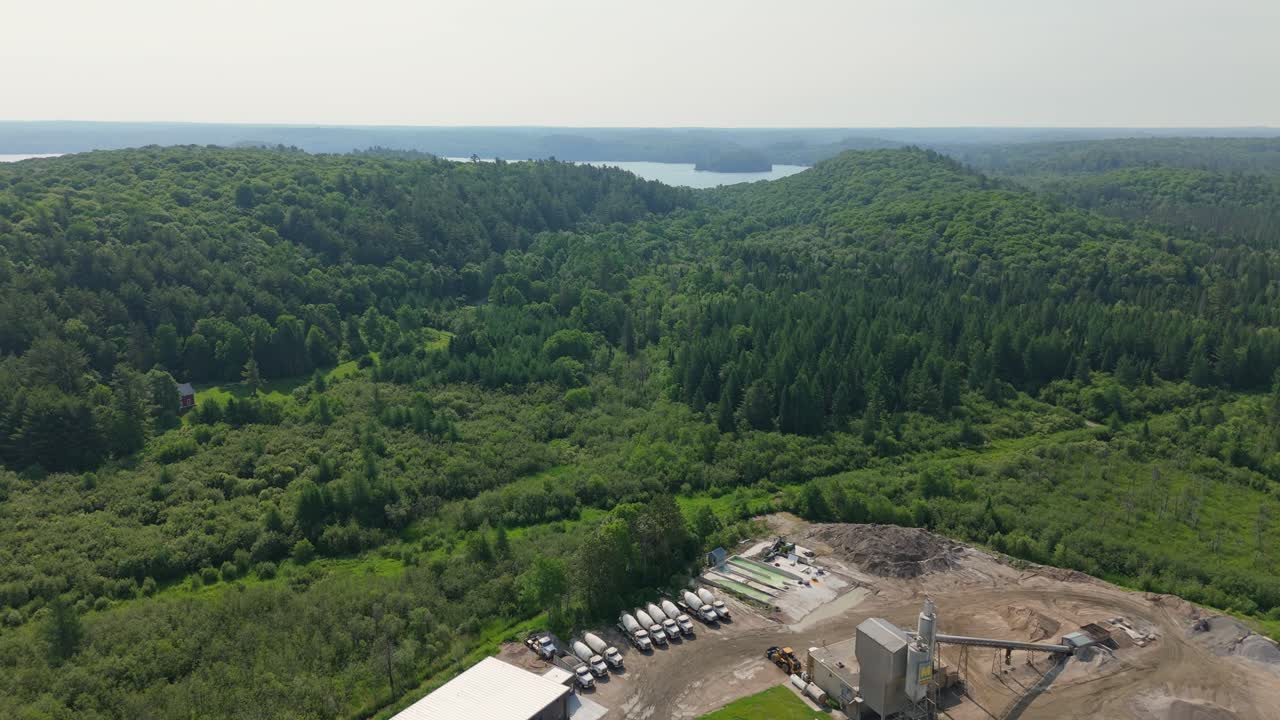 Ready mix concrete plant with a mix of industrial equipment and natural landscape