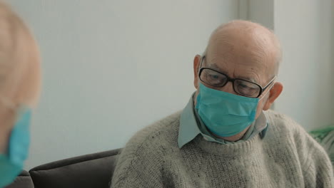 female caring nurse measures the old man temperature with infrared thermometer