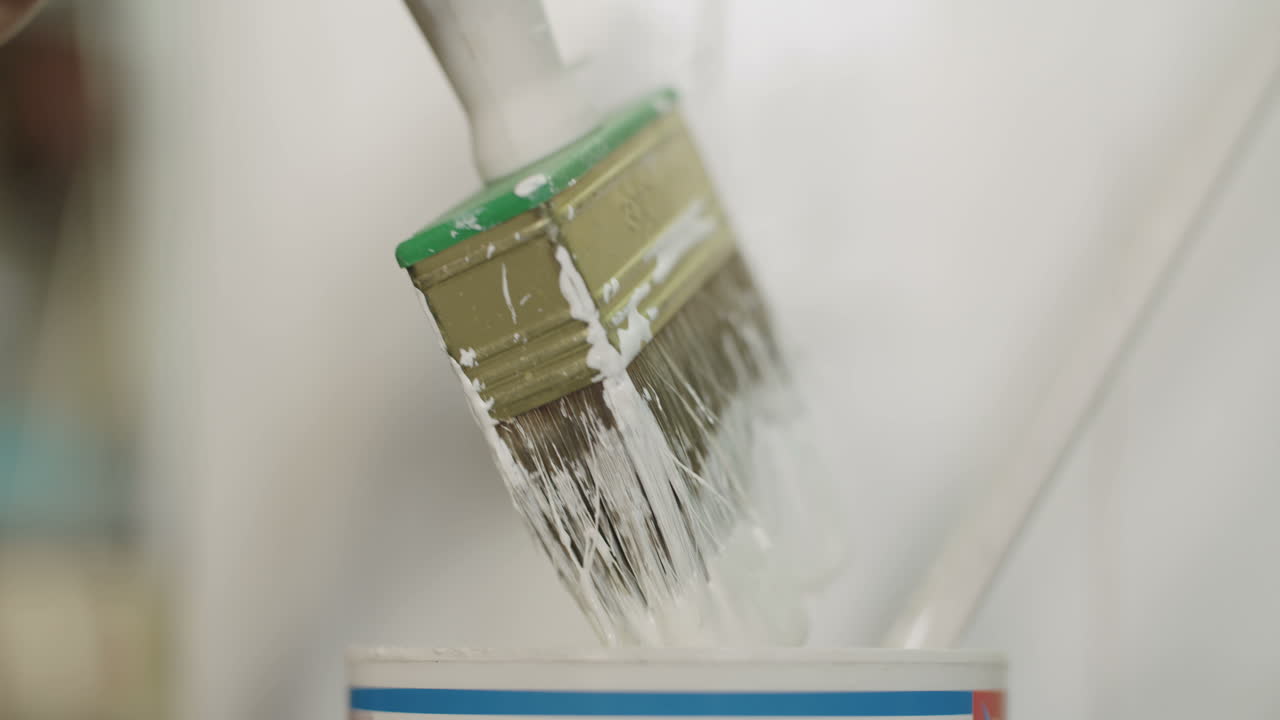 흰색 페인트로 나무 판자를 칠하는 청년