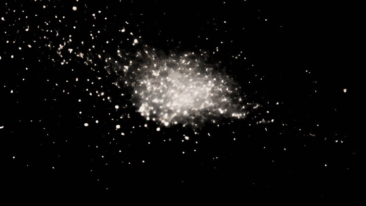Esplosione Dinamica di Particelle Bianche su Sfondo Nero
