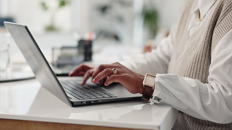Person, die auf einem Laptop schreibt
