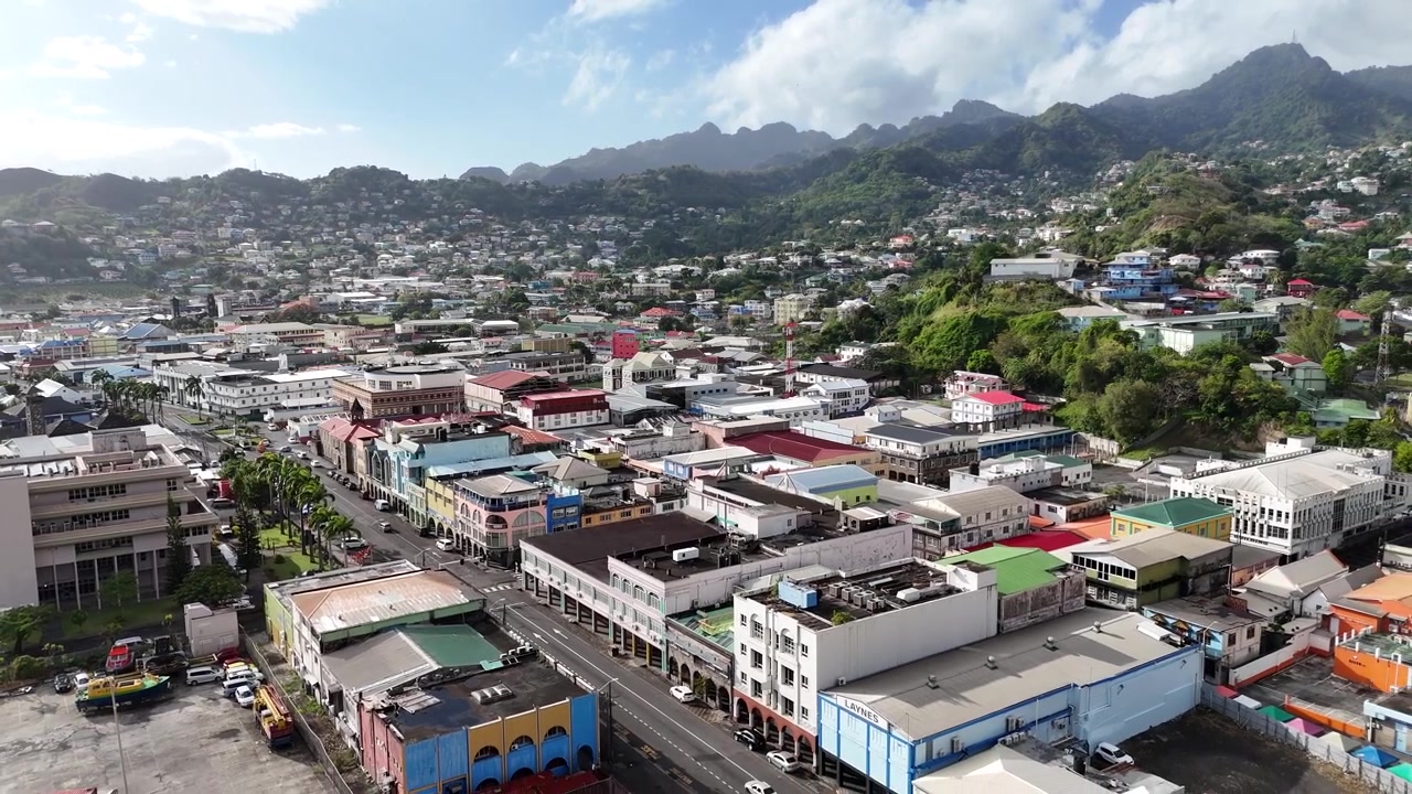 Panorama aéreo de Kingstown, a capital de São Vicente e Granadinas. Paisagem urbana mostrando telhados coloridos, configuração de porto costeiro e colinas tropicais.
