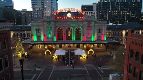 aerial drone descending shot of union station lit up during a peaceful evening