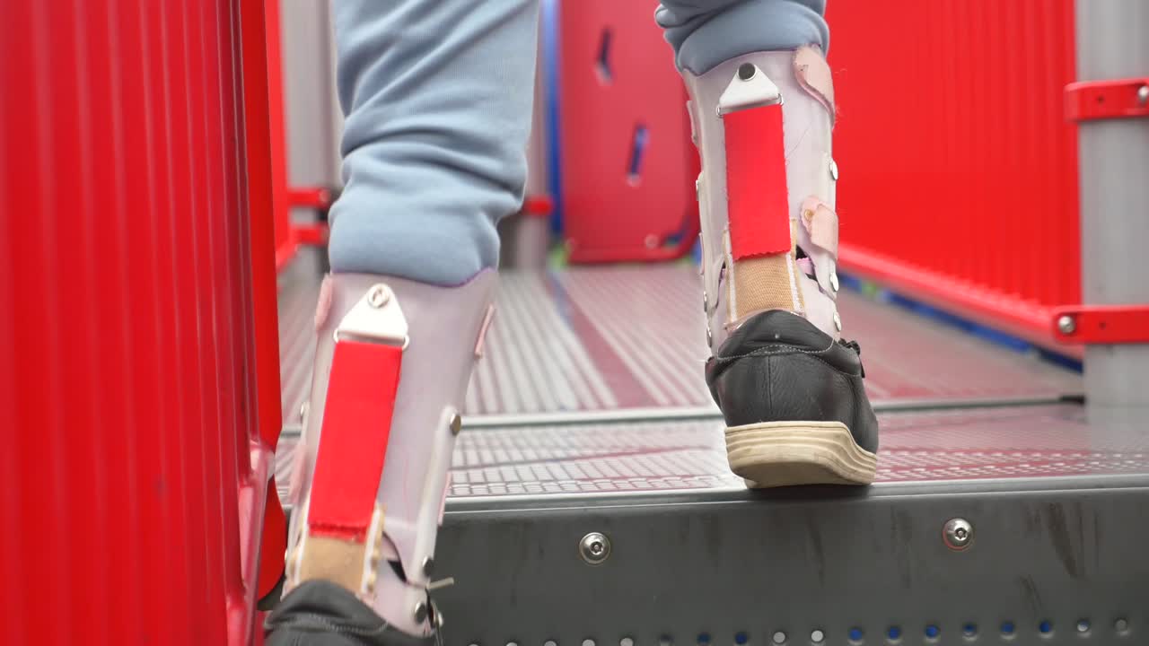 발목 브레이스를 착용한 어린 소녀가 놀이터에서 놀고 있습니다.