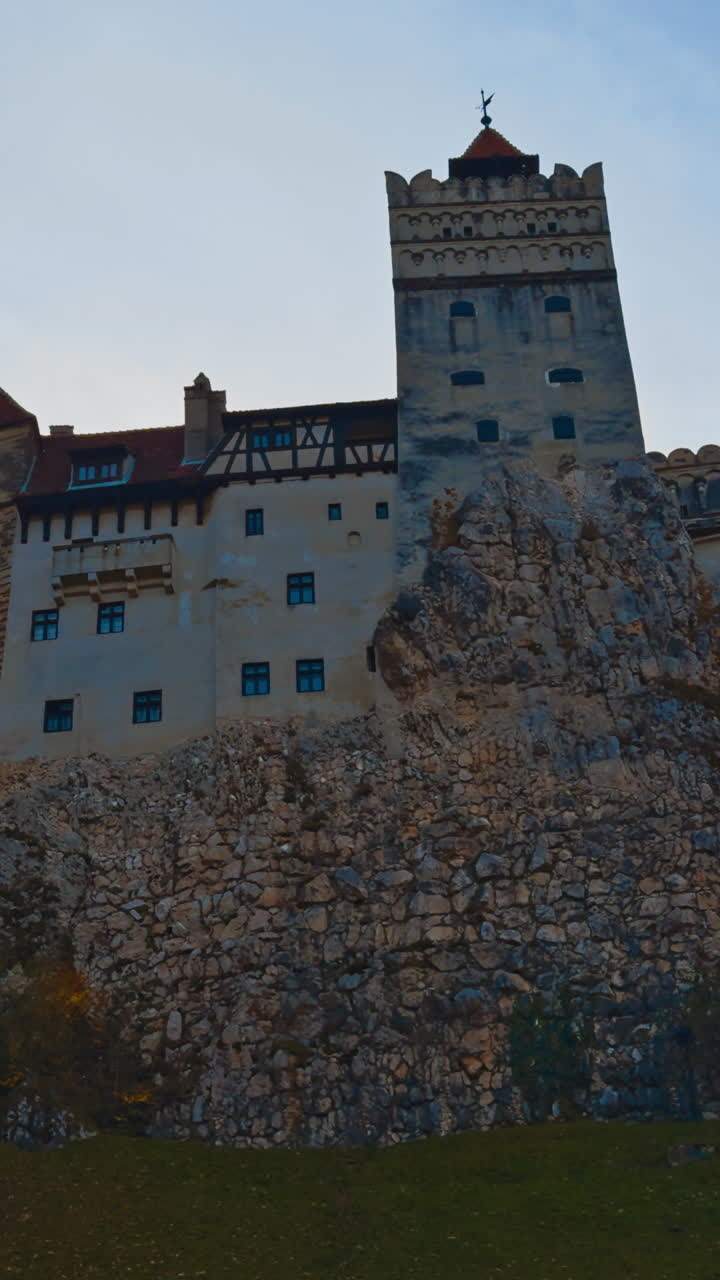 Beautiful castle Bran the concealment on vicious Count Dracula. Low angle view of the historic building in autumn nature. Vertical video