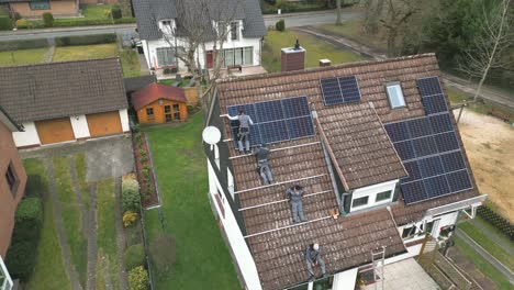 workers install a solar panel system on the roof of a single-family home. pulling up the panels. solar energy - eco-friendly power source