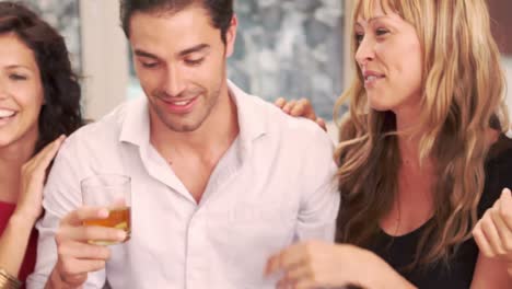 handsome man with whiskey discussing with women