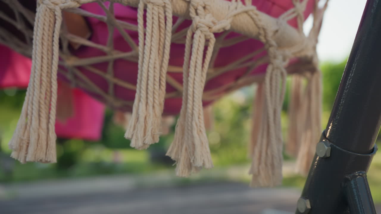 Sunlit Woven Tassels Dance, Sunlight Illuminates Moving Hammock Tassels And Warm Summer Backdrop, Relaxing Patio Scene Featuring Swinging Fringe Illuminated By Sunlight And Summer Atmosphere
