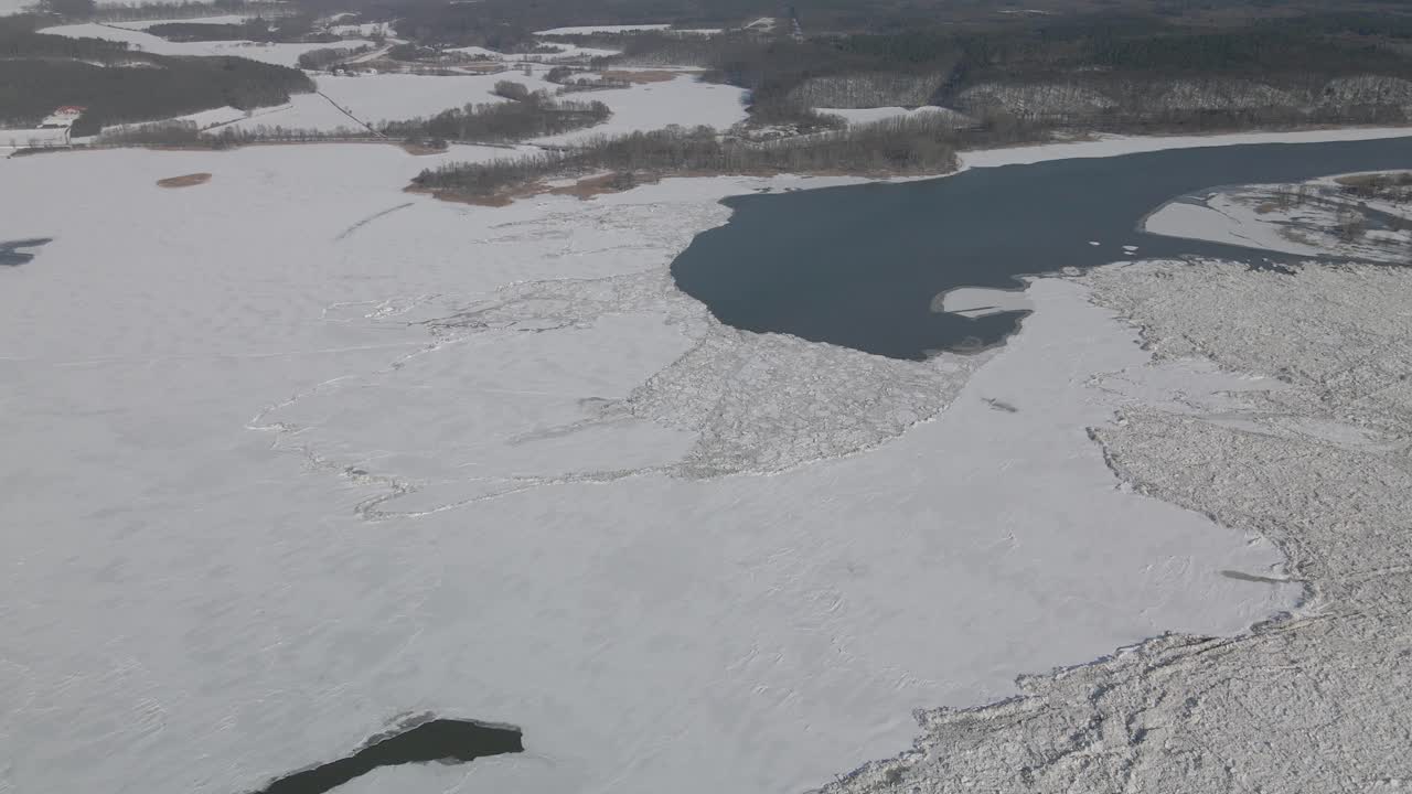 북유럽의 강한 겨울 동안 떠다니는 얼음과 얼어붙은 제방이 있는 대강의 공중 촬영