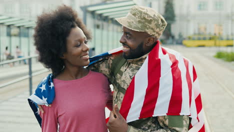 cheerful couple hugging and smiling outdoors