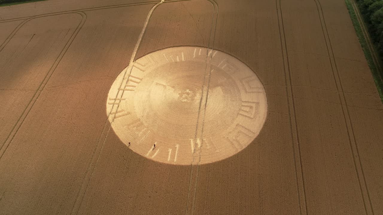 Establishing aerial view plowed farmland remains of golden crop circle formation in Wiltshire