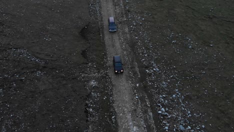 해질 무렵 올림푸스 산 그리스의 바위산 비포장 도로에서 운전하는 두 대의 오프로드 자동차를 추적한 드론 비디오