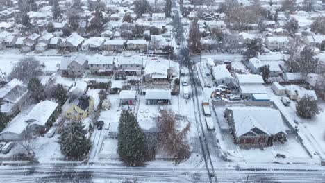 toma de drones de un vecindario de spokane cubierto de nieve con copos de nieve cayendo activamente