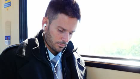 businessman using mobile phone while listening to music