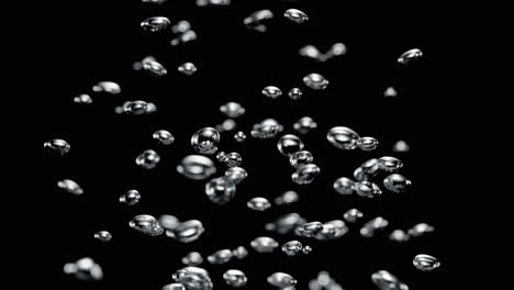 small air bubbles rise from the bottom up in the black water depths in macro and slow motion, side view