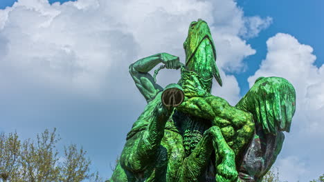 Timelapse-low-angle-shot-of-the-statue-in-Hamburg,Germany-in-a-clear-blue-sky-with-white-clouds-passing-by-in-the-background