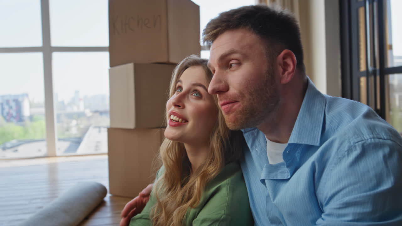 Tired couple moving house sitting modern apartment between carton boxes closeup