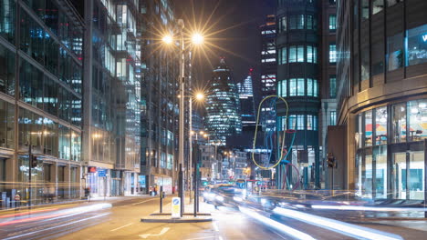 Night time lapse of a busy road in London, UK with cars and buses zooming past and famous skyscrapers in the background