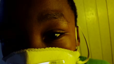 close-up on a african boy's sad eyes wearing a medical mask.