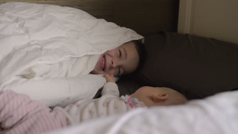 un niño feliz con su hermana pequeña en la cama