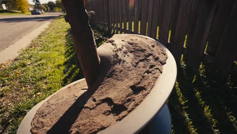 closeup of a large auger covered in dirt after digging a hole