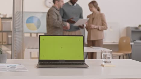laptop with chromakey in busy office