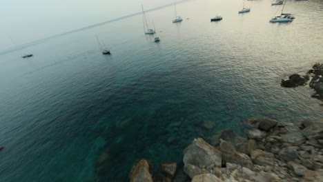 Fpv-Drone-Adelante-Moviendo-Tiro-Sobre-Veleros-Atracados-A-Lo-Largo-De-La-Playa-En-La-Playa-De-Cala-D&#39;egos,-Mallorca,-España