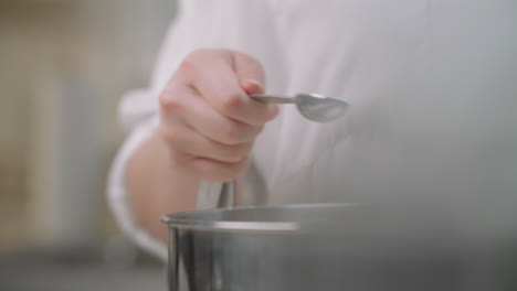 pouring salt into a mixing bowl from a measuring spoon