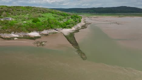 Rugged-rocky-coastline-with-verdant-green-foliage-and-receding-tide