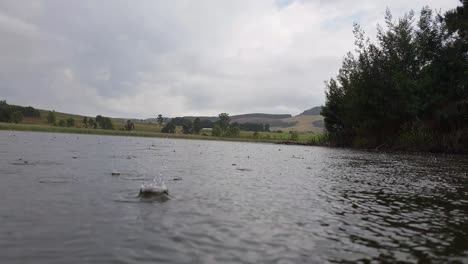 Lluvia-Cayendo-Sobre-Un-Hermoso-Y-Tranquilo-Lago-En-Natal,-Sudáfrica