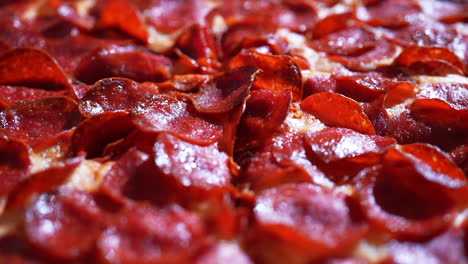 pizza recouverte de pepperoni appétissant et fraîchement sortie du four - avance lente en gros plan