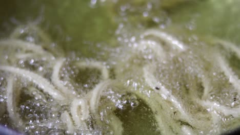 frito en cámara lenta en aceite caliente, aceite hirviendo comida frita receta murukku bocadillos indios hechos durante el festival de deepavali