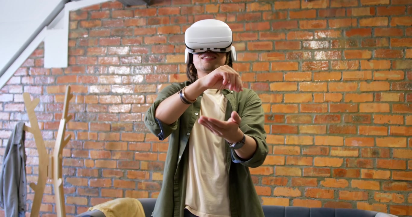 Homem usando óculos de VR seguindo instruções do headset, alcançando e manipulando interface de usuário virtual em um loft.
