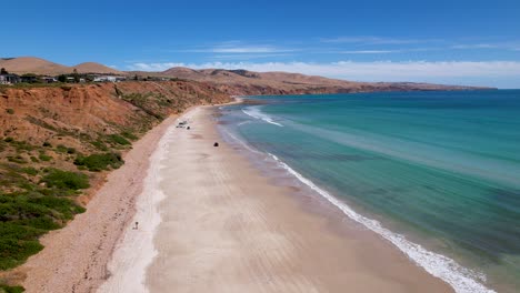 A-drone-view-of-cars-driving-on-a-white-sand-beach-in-South-Australia