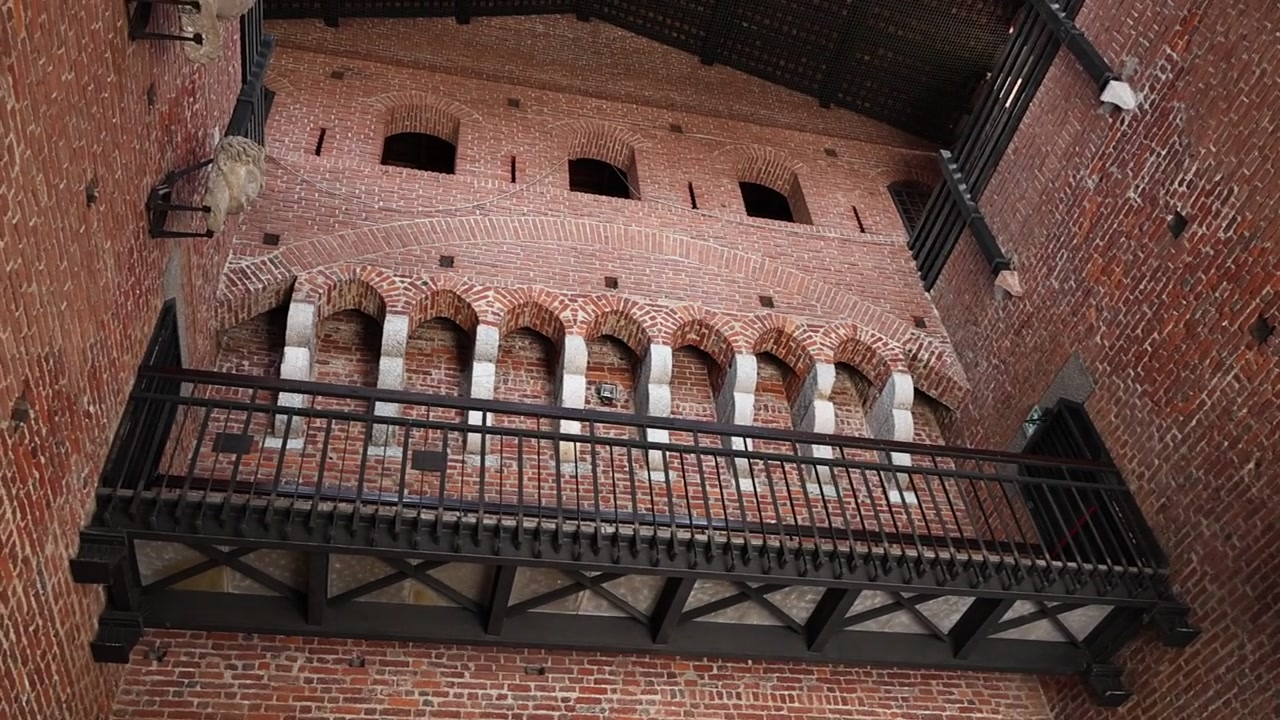Vista interna di un muro di un castello storico in mattoni con balcone.