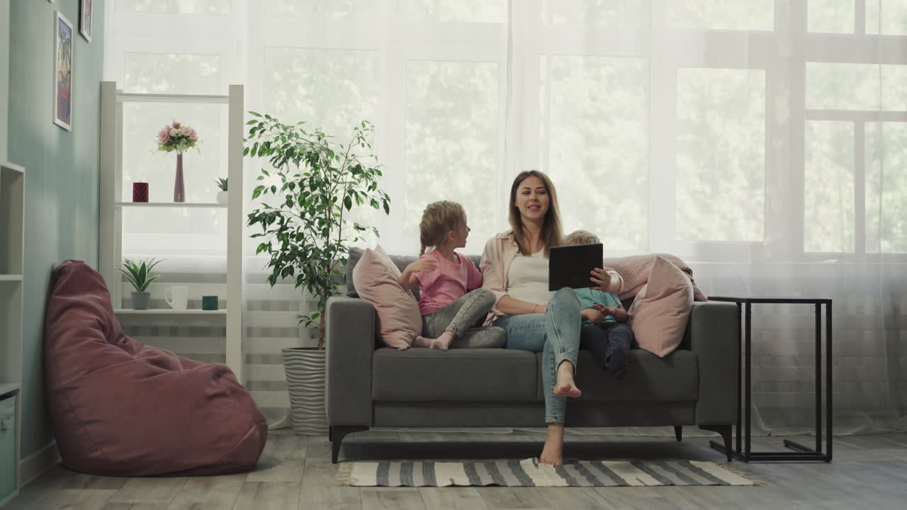 chica se ríe viendo videos divertidos con su madre y su hermano