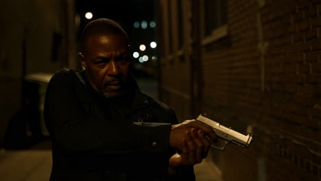 intense man holding a firearm at night
