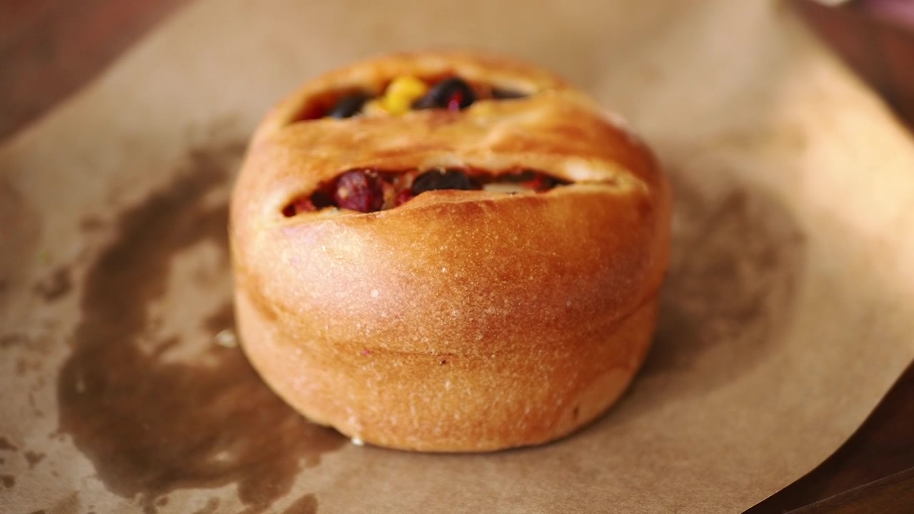 Hand Picking Up a Freshly Baked Savory Stuffed Bun