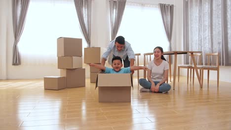 happy family is having fun with cardboard boxes in new house