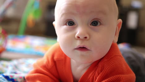 a cute six month old baby looks up with surprise in slow motion