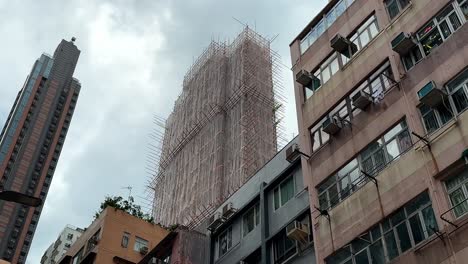 daytime shot of hong kong high rise with bamboo scaffolding and gloomy sky