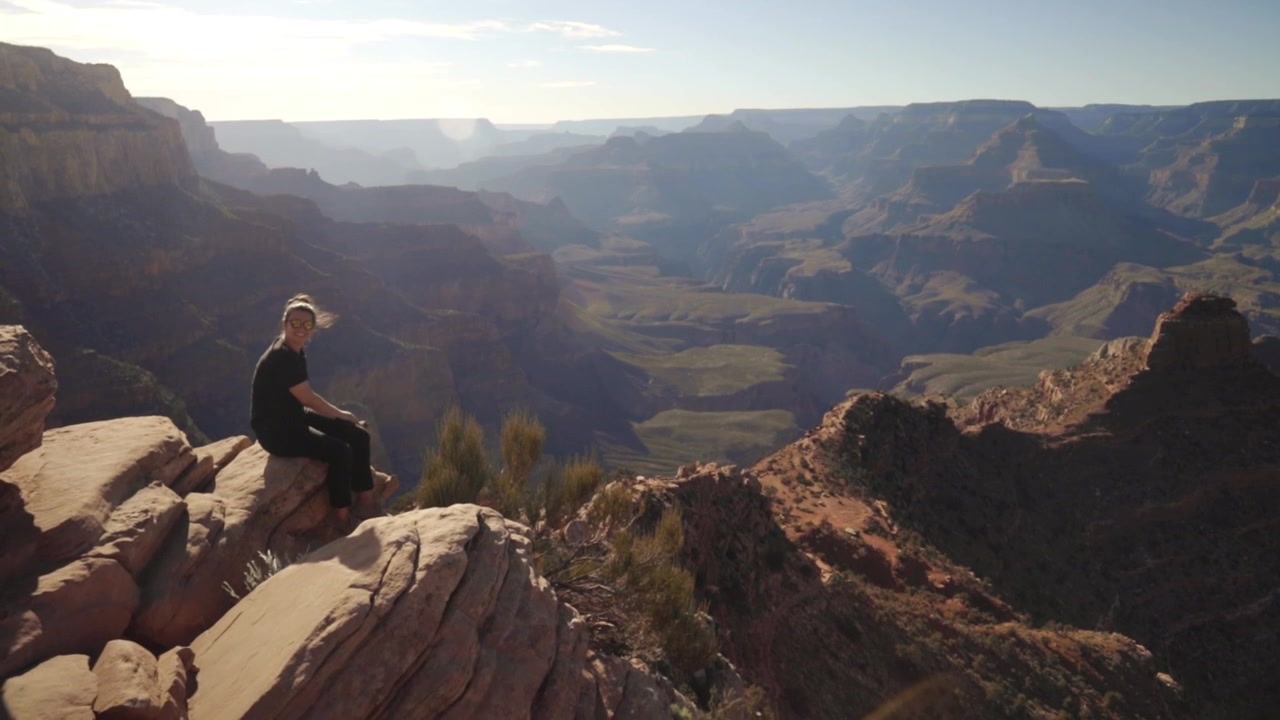 Woman sitting on edge of cliff. View of Grand Canyon on the South Kaibab trail. Ohh Ahh point.