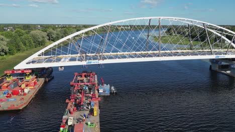 aerial orbits large arch bridge being moved into position over river