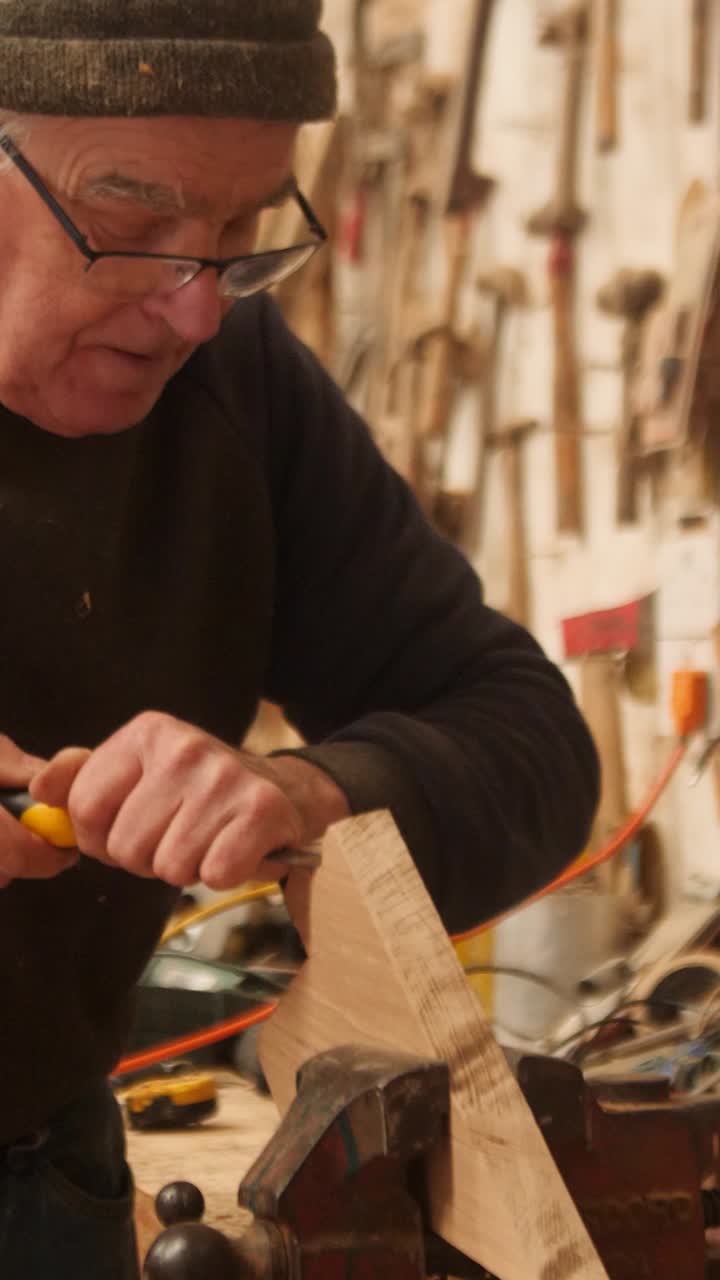 Experienced carpenter shapes oak with chisel
