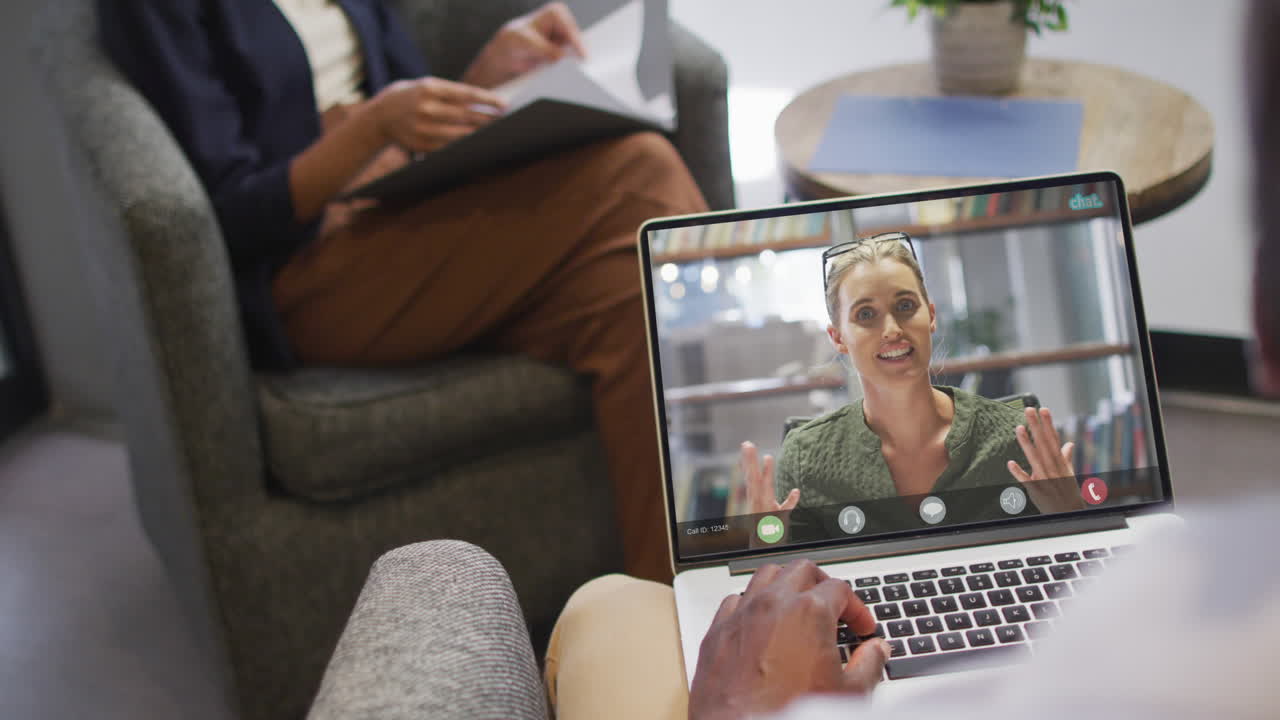 African american businessman using laptop for video call with caucasian business colleague