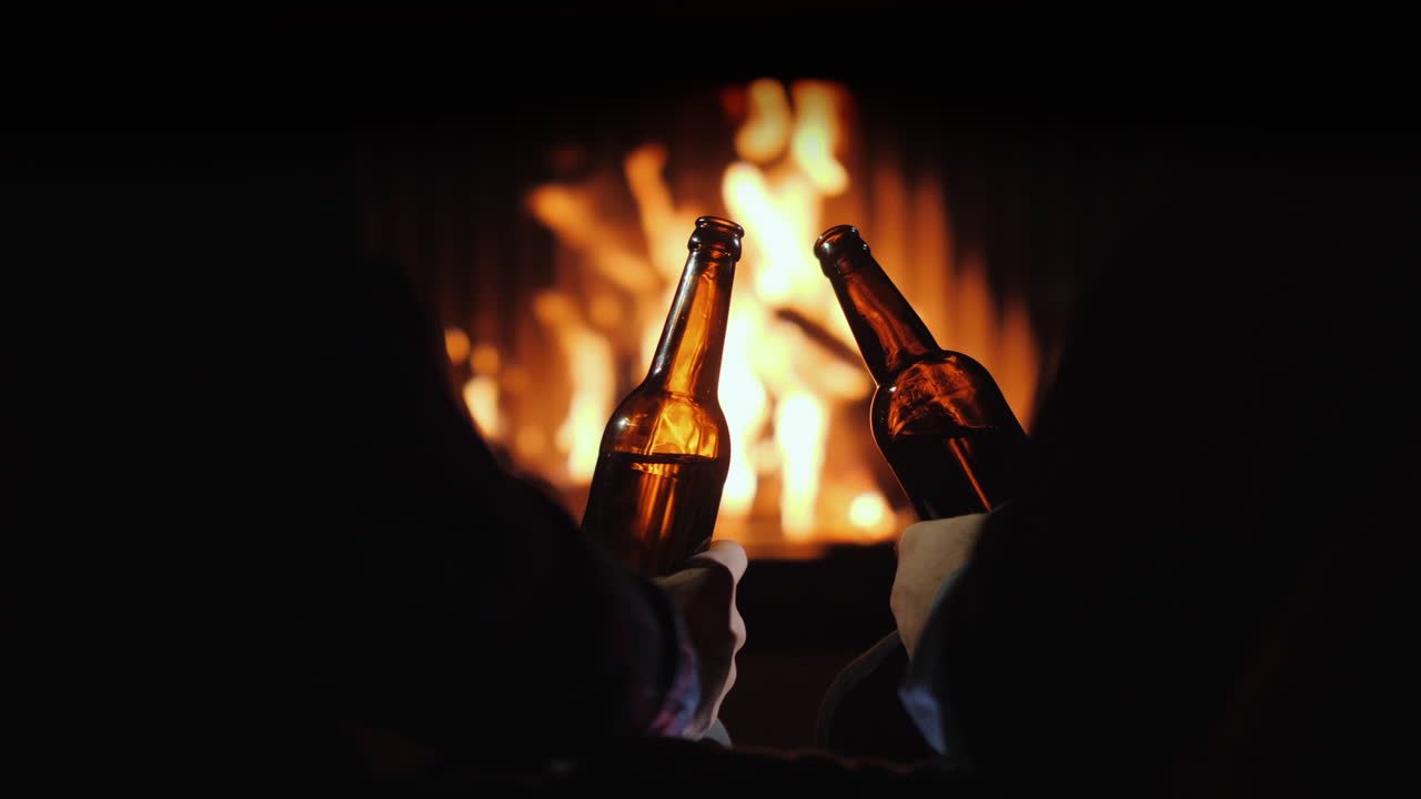 descanso masculino con cerveza junto a la chimenea escape de invierno video 4k