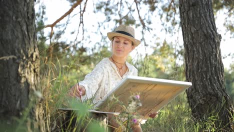beautiful adult woman drawing in a summer field girl artist paints in nature beautiful adult woman drawing in a summer field
